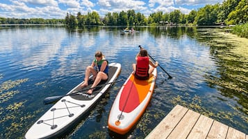Two paddleboards on calm water with a dock in the foreground.
