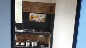 A narrow hallway leading to a kitchen with a tiled backsplash, a wooden ceiling, and a window. - CABAÑAS VILLAS DEL LAGO (Cuitiva)
