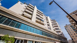A modern multi-story building with large windows and balconies.