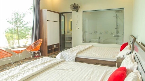 A hotel room with two beds, a large window, a balcony with chairs, and a shower area. - Coto Island Summer Hotel (Co To)