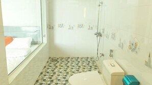 A bathroom with a toilet, a sink, a shower, and a window. - Coto Island Summer Hotel (Co To)