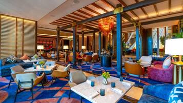 A spacious lobby with a mix of seating areas, including sofas and chairs, and a patterned carpet.
