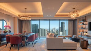 A modern living room with a dining area, large windows with a city view, and contemporary furnishings. - Solaire Resort Quezon City – Previously known as Solaire Resort North (Quezon City)