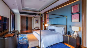 Una habitación de hotel moderna con una cama grande, un escritorio y una televisión.