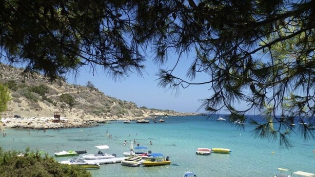 A coastal scene with boats and people on a clear day.