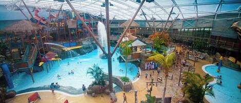 Un parc aquatique intérieur doté de plusieurs piscines, de toboggans et d’aires de jeux.
