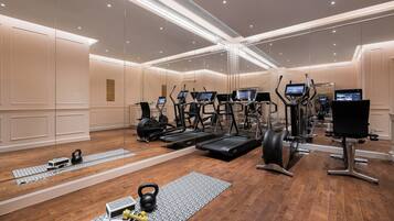 Ein modernes Fitnessstudio mit Laufbändern, Crosstrainern und Kurzhanteln.