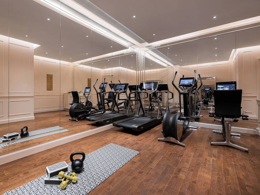 Ein modernes Fitnessstudio mit Laufbändern, Crosstrainern und Kurzhanteln.