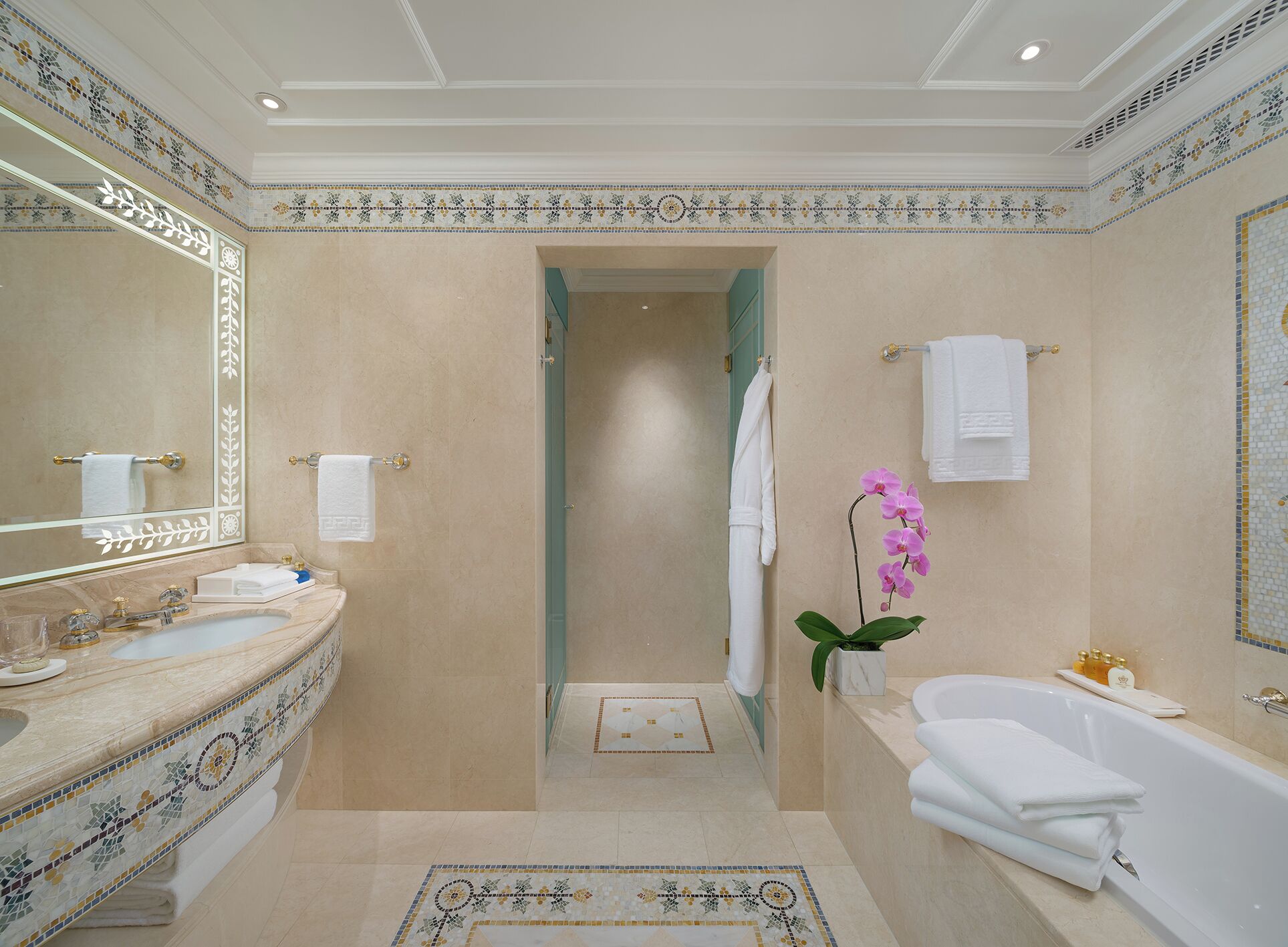 A spacious bathroom with a large mirror, a bathtub, and a shower area.