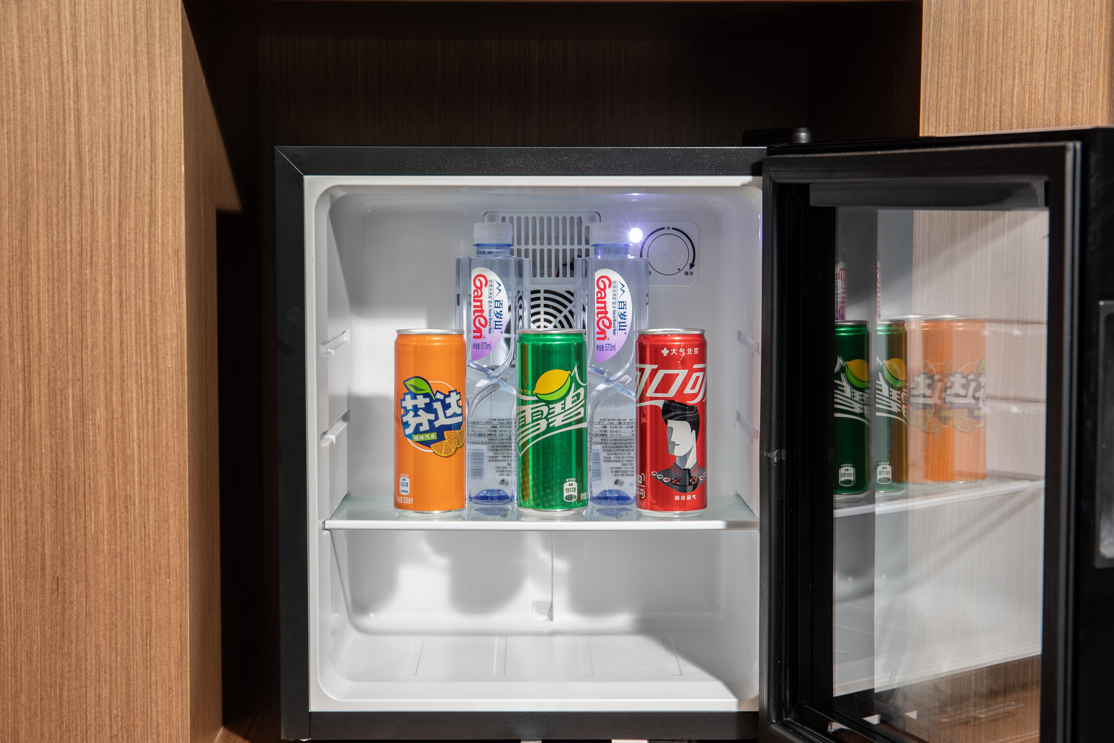 Un refrigerador con varias latas de bebidas.