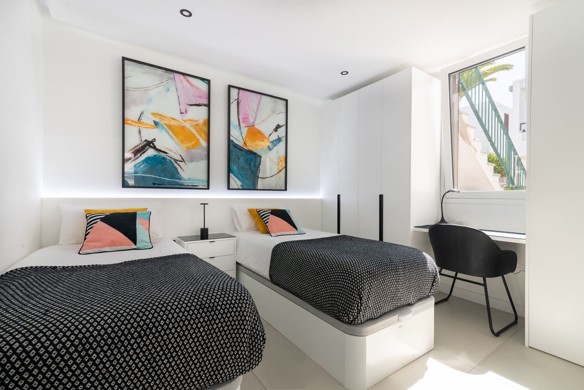 Une chambre moderne avec deux lits, un bureau et une chaise.