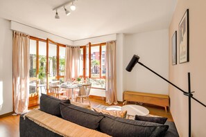 A modern living room with a sofa, a round table, and a bench.