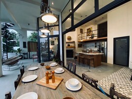 Una cocina moderna con una isla grande, electrodomésticos de acero inoxidable y un comedor con una mesa de madera alargada para seis comensales.