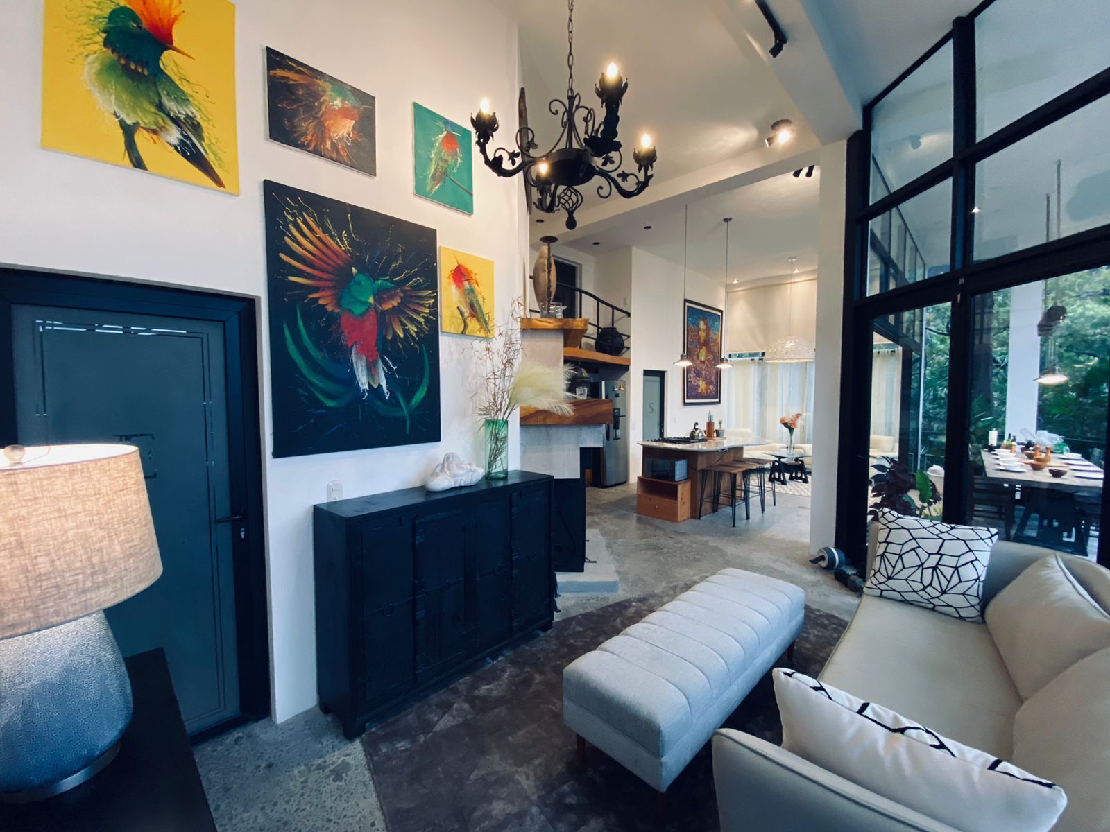 En moderne stue med sofa, spiseområde og kunst på væggene.