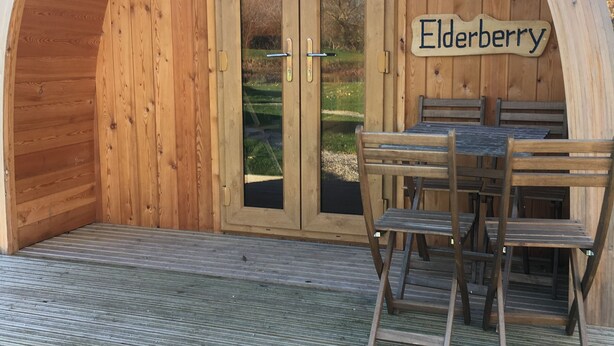 A wooden structure with a sign reading "Elderberry." - Somerset glamping pod with access to adventure activities. (East Huntspill)