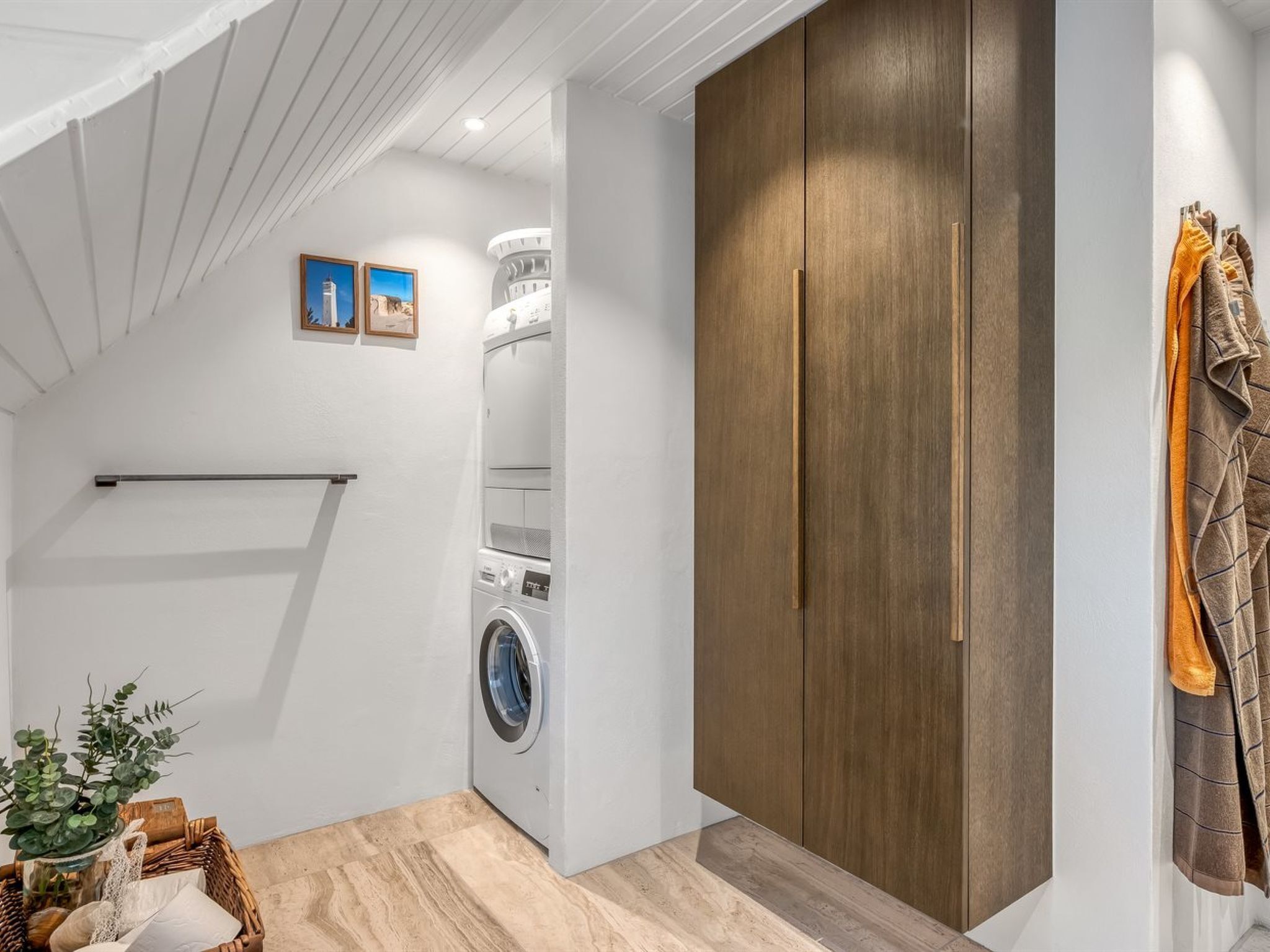 Ein Waschraum mit Waschmaschine, Trockner und Holzschrank.