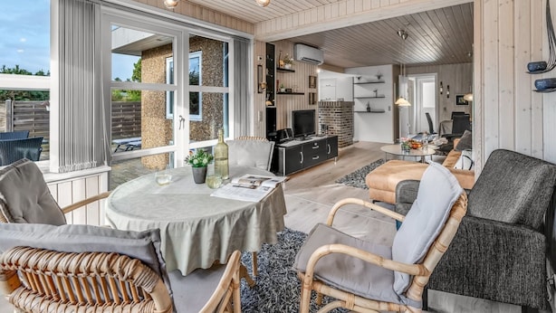 A spacious living area with a round table, wicker chairs, a sofa, and a television. - "Geert" - 900m from the sea by Interhome (Blåvand)