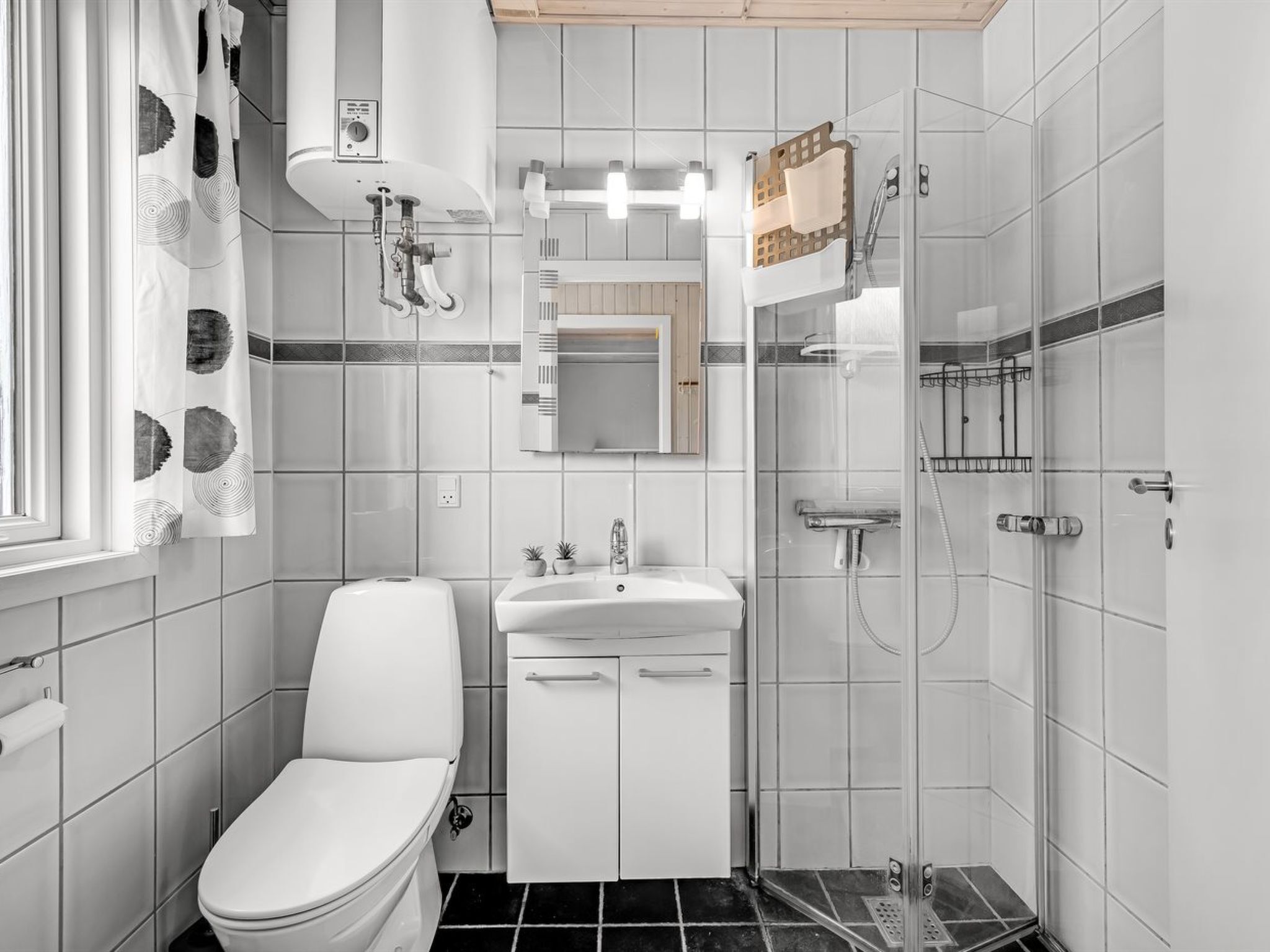 Ein kleines, modernes Badezimmer mit Toilette, Waschbecken und Dusche.