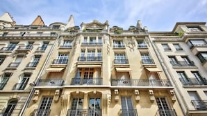 Ein mehrstöckiges Gebäude mit Balkonen, großen Fenstern und klassischer Architektur.