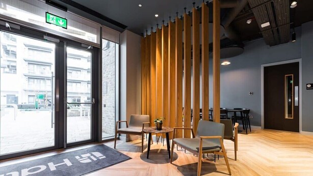 Un intérieur moderne comprenant un comptoir d’accueil, un espace détente et une grande fenêtre donnant sur la rue.