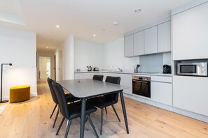 A modern kitchen with white cabinets, a Bosch microwave, and a Bosch oven.