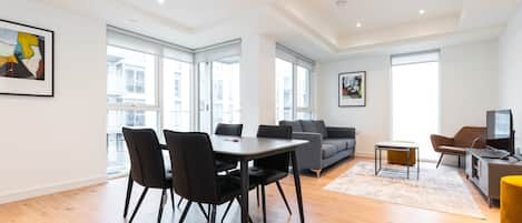 Amplia sala de estar con una mesa de comedor, sofás y televisor.