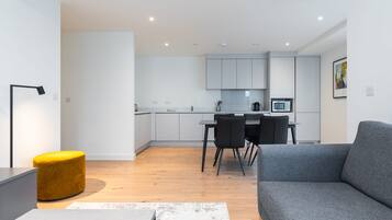 A modern apartment with a dining area, kitchen, and living room.