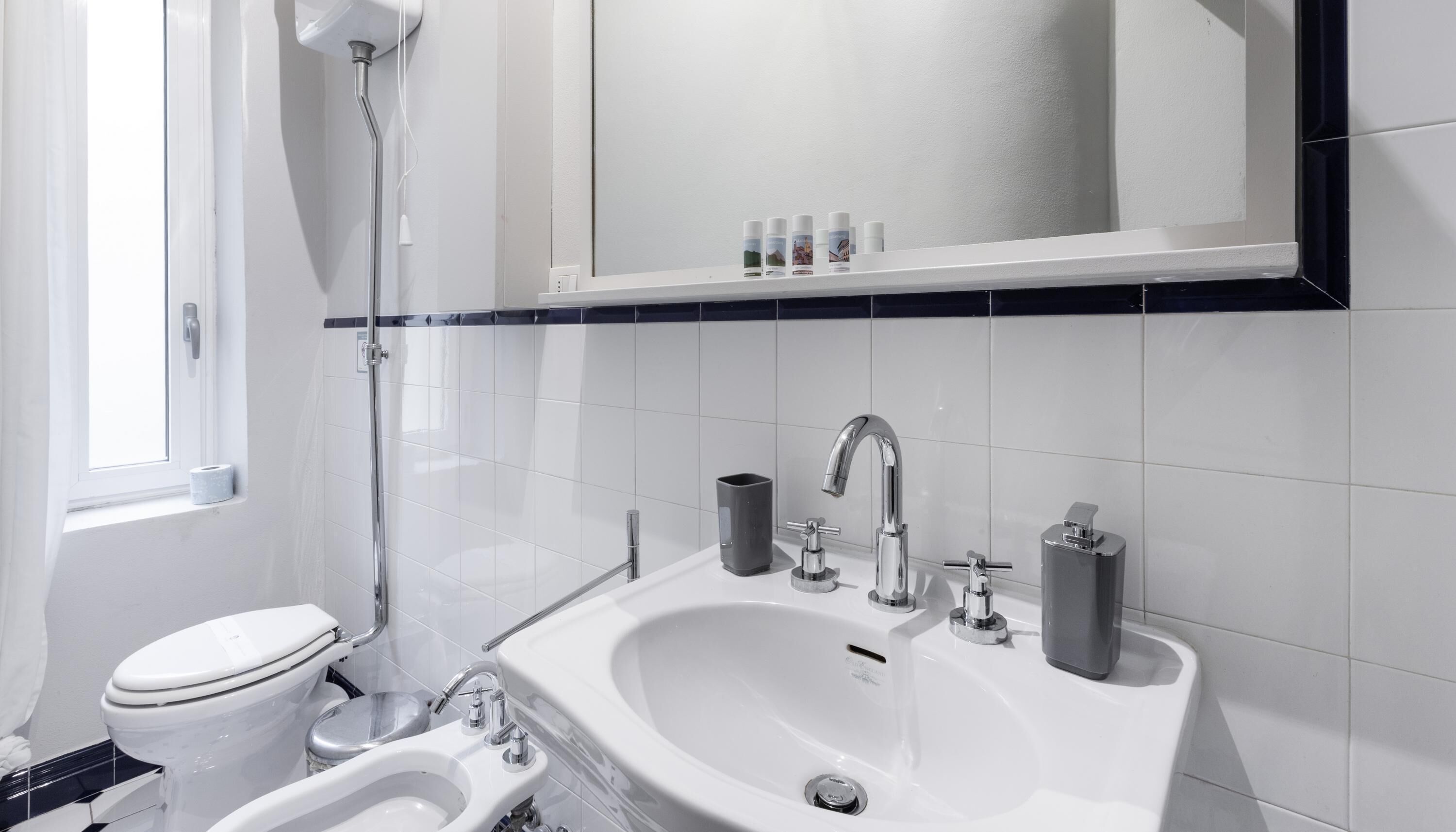 Une salle de bain moderne équipée de toilettes, d’un bidet, d’un lavabo et d’un miroir.