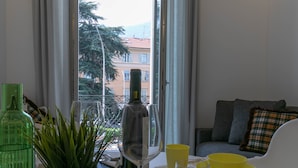 Un coin repas avec une table dressée pour deux personnes, un verre à vin, des bols jaunes et une plante verte.