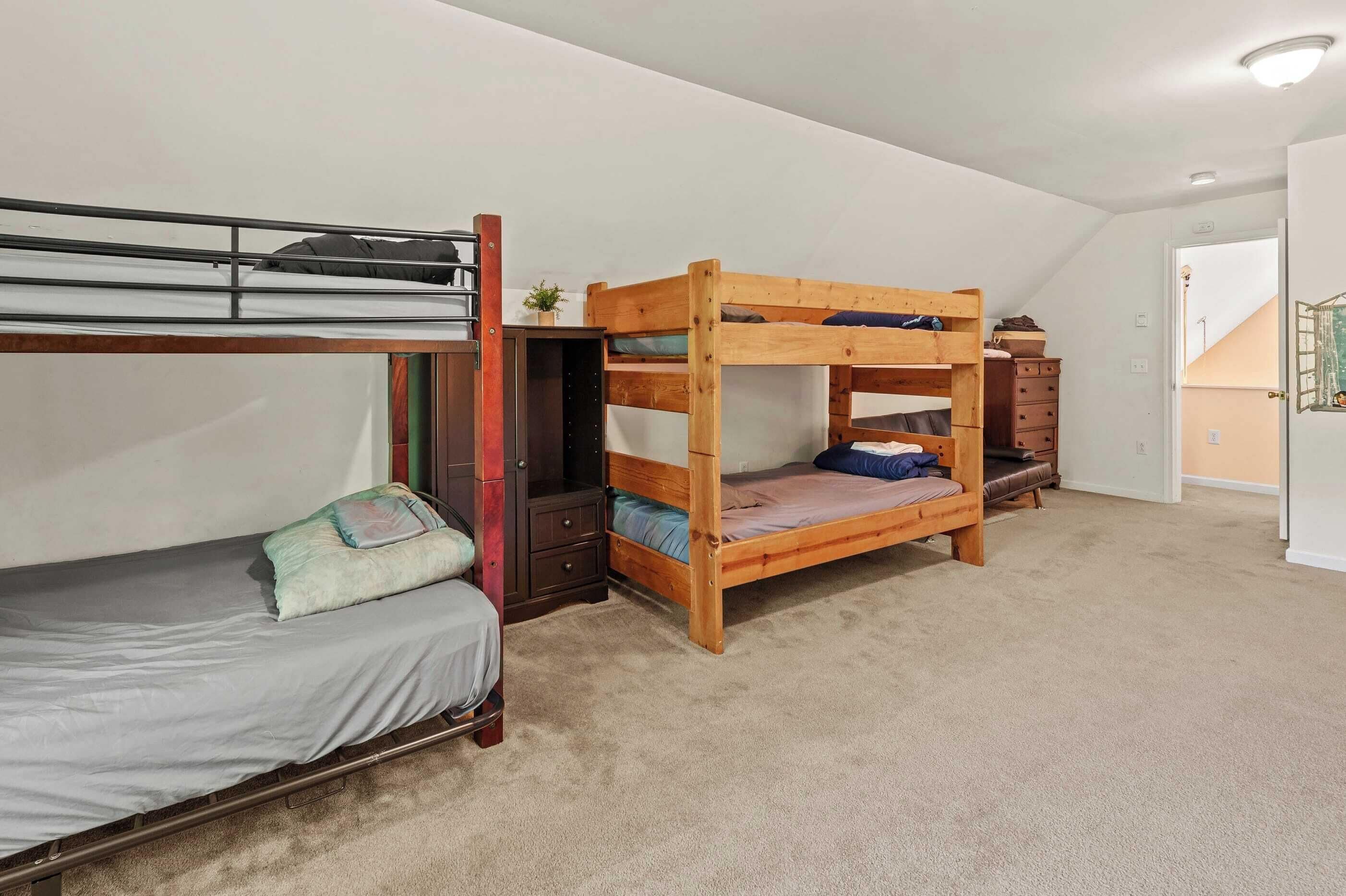 Quarto com beliche, escrivaninha e cômoda.