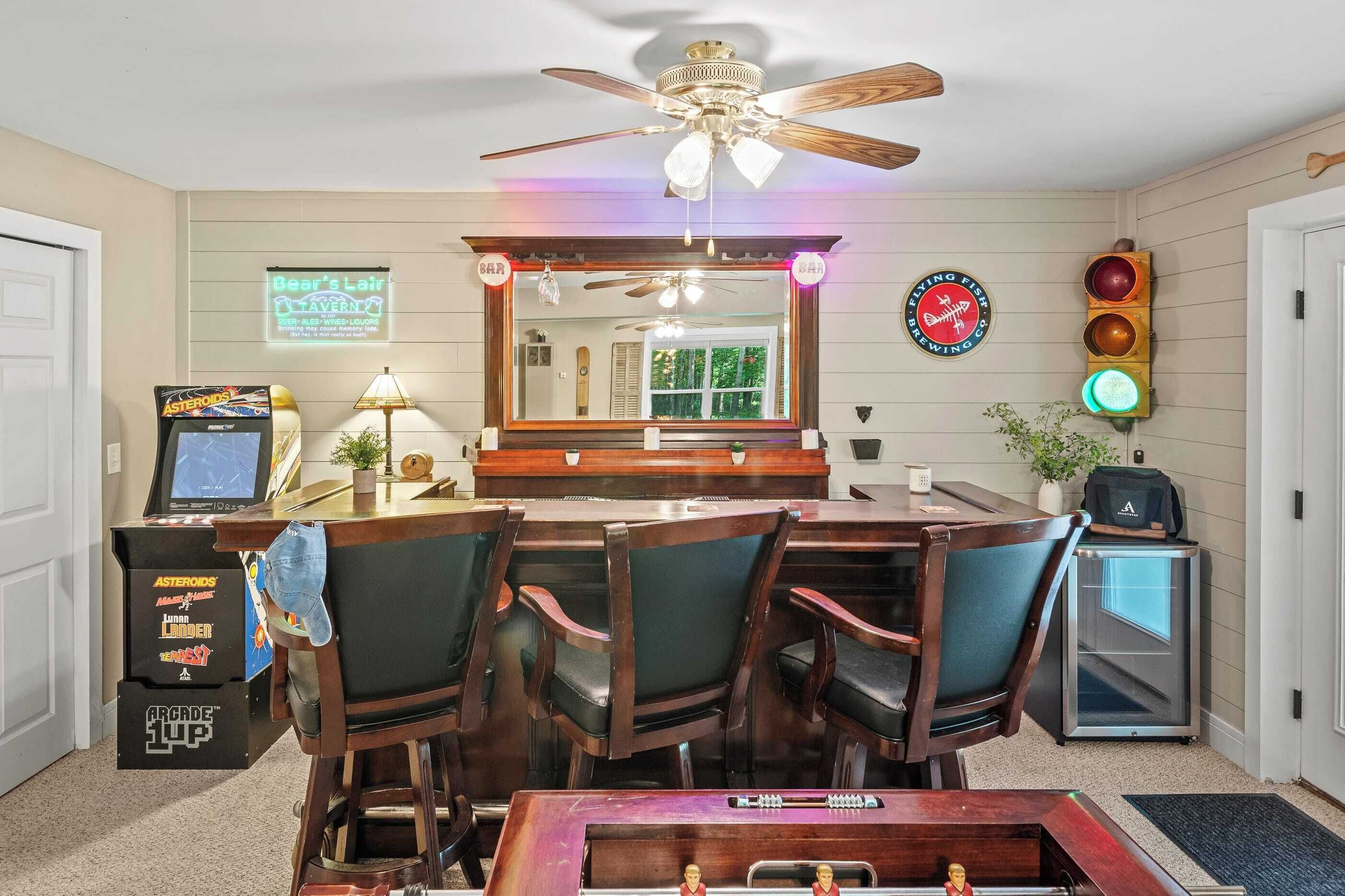 A room with a bar area, arcade games, a mirror, and a traffic light decoration.