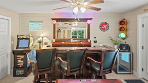 A bar area with a mirror, arcade machines, and a seating arrangement. - Alpine Serenity by Avantstay Beach + Lake Access Theater, Deck, Playroom (Albrightsville)
