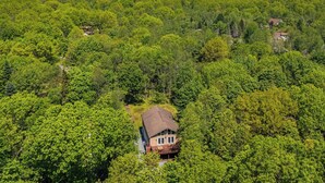 A house surrounded by dense forest, with a clear view of the surrounding landscape. - Mews Mountain House by Avantstay Walk to Beach, Hot Tub, Game Room (Albrightsville)