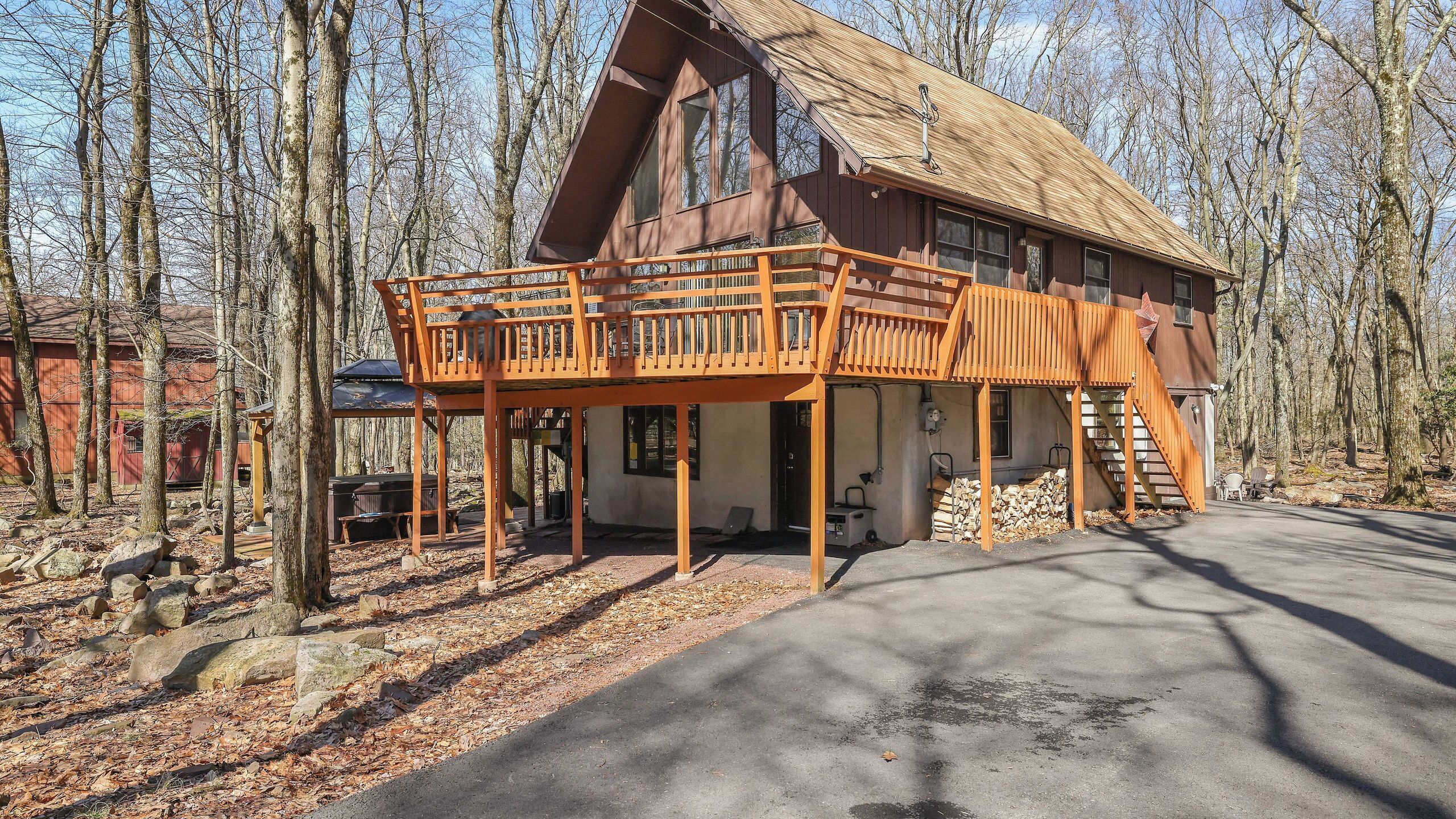 Une cabane dotée d’une terrasse en bois, d’un porche couvert et d’un escalier menant à l’étage supérieur.