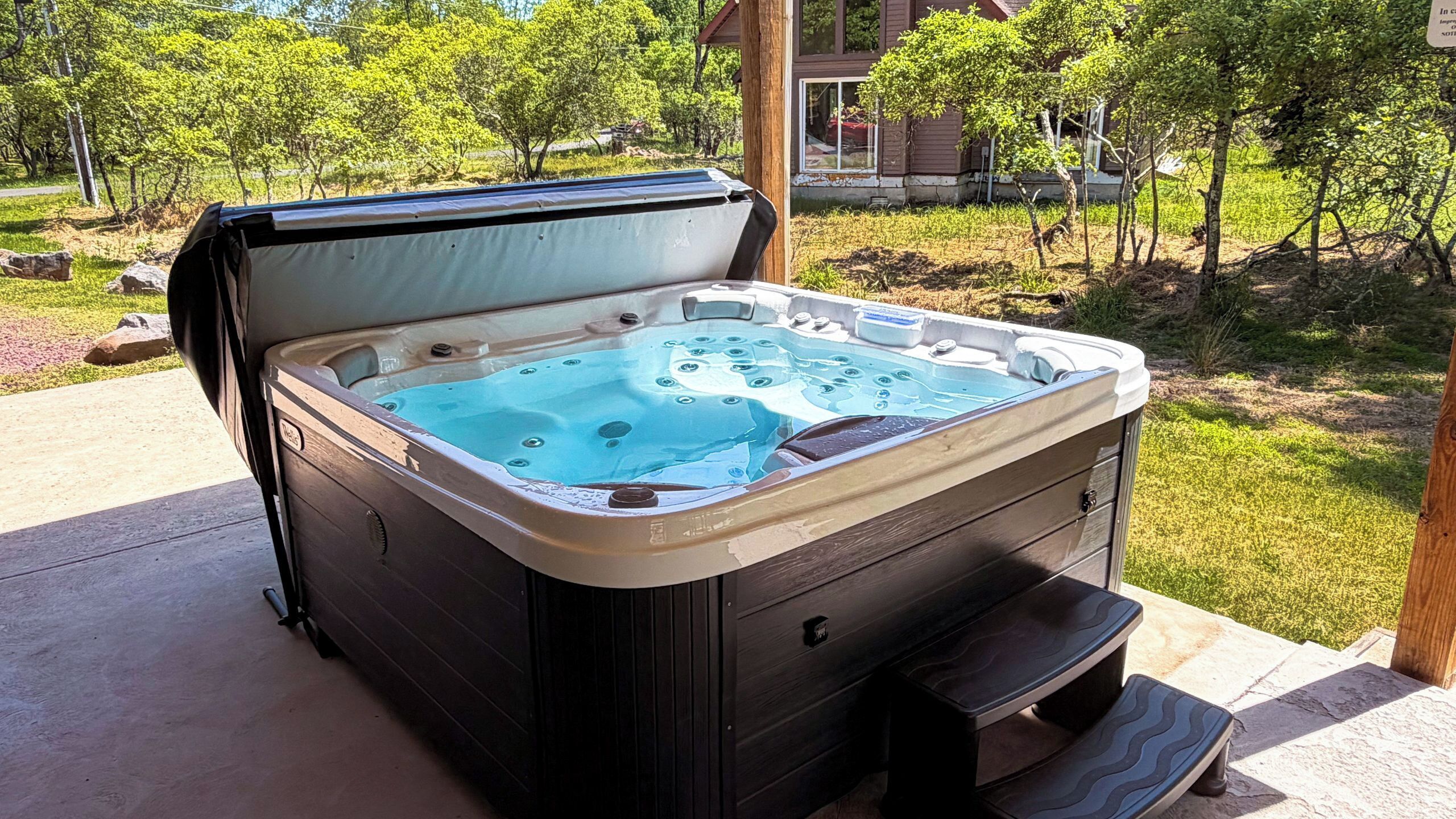 Ein Whirlpool mit Holzverkleidung, Deckel und Pumpe.