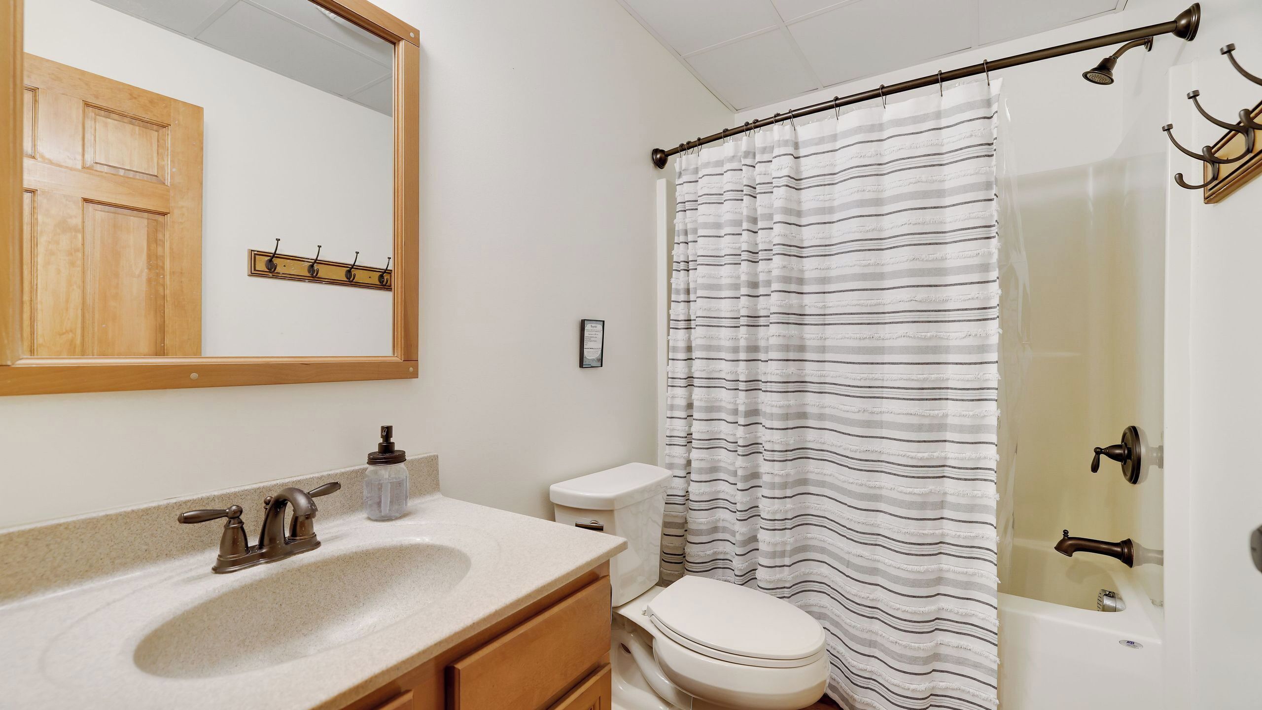 A bathroom with a sink, toilet, and shower curtain.