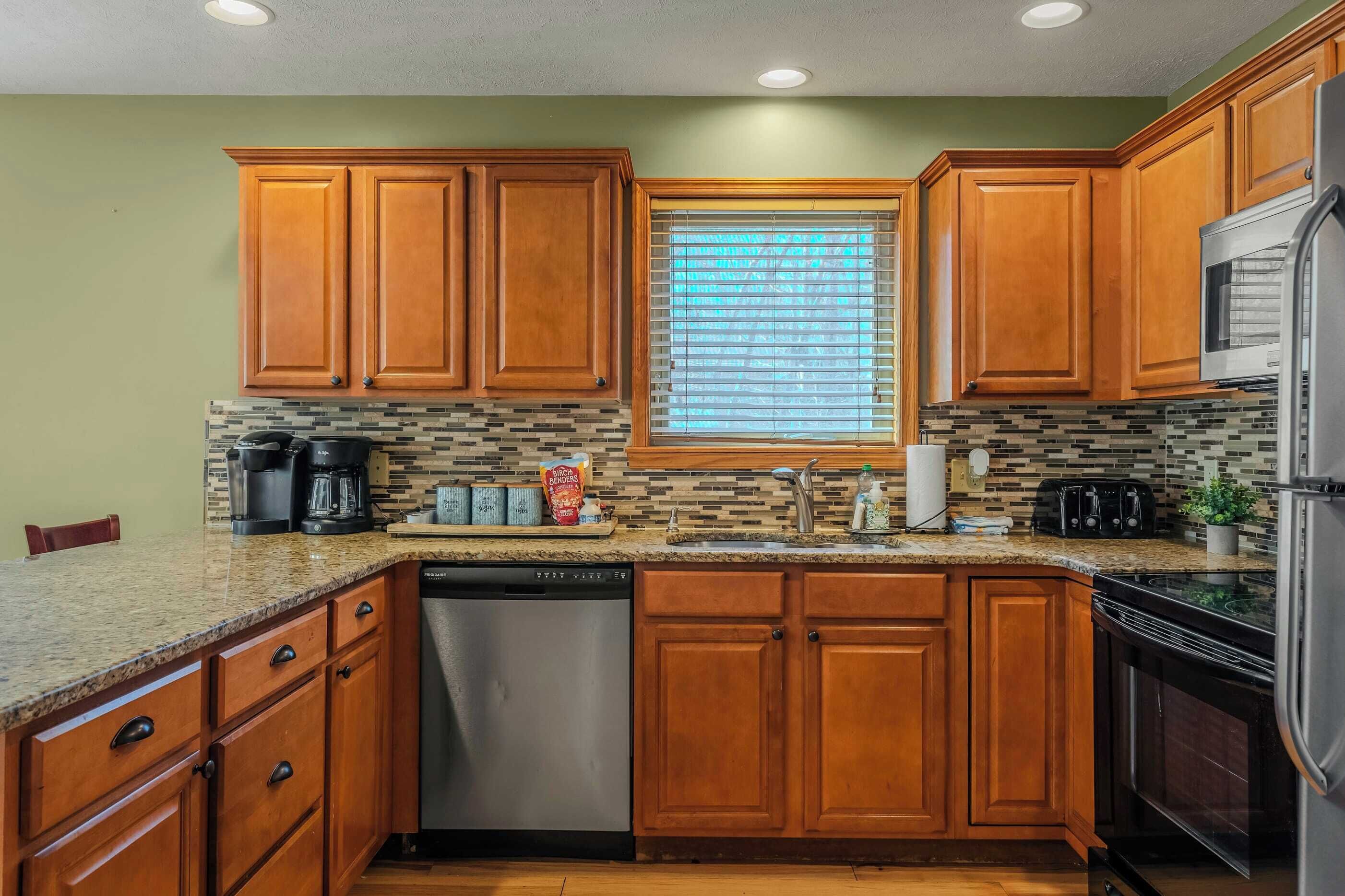 A kitchen with wooden cabinets, a dishwasher, a microwave, and a refrigerator.