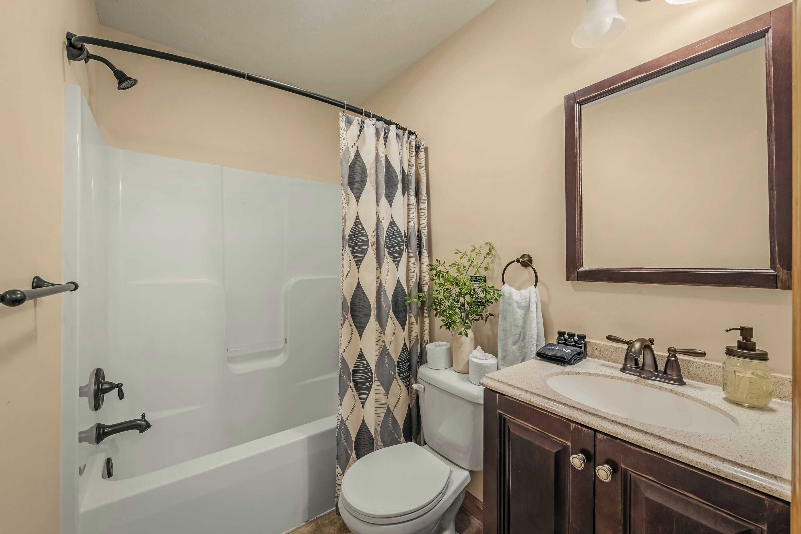 A bathroom with a bathtub, toilet, and sink.
