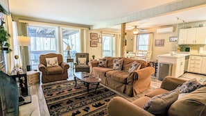 A cozy living room with a sofa, chairs, a coffee table, and a patterned rug. - Harmony Cottage by Avantstay Lake Access, Hot Tub, Fire Pit, & Game Room (Lake Harmony)