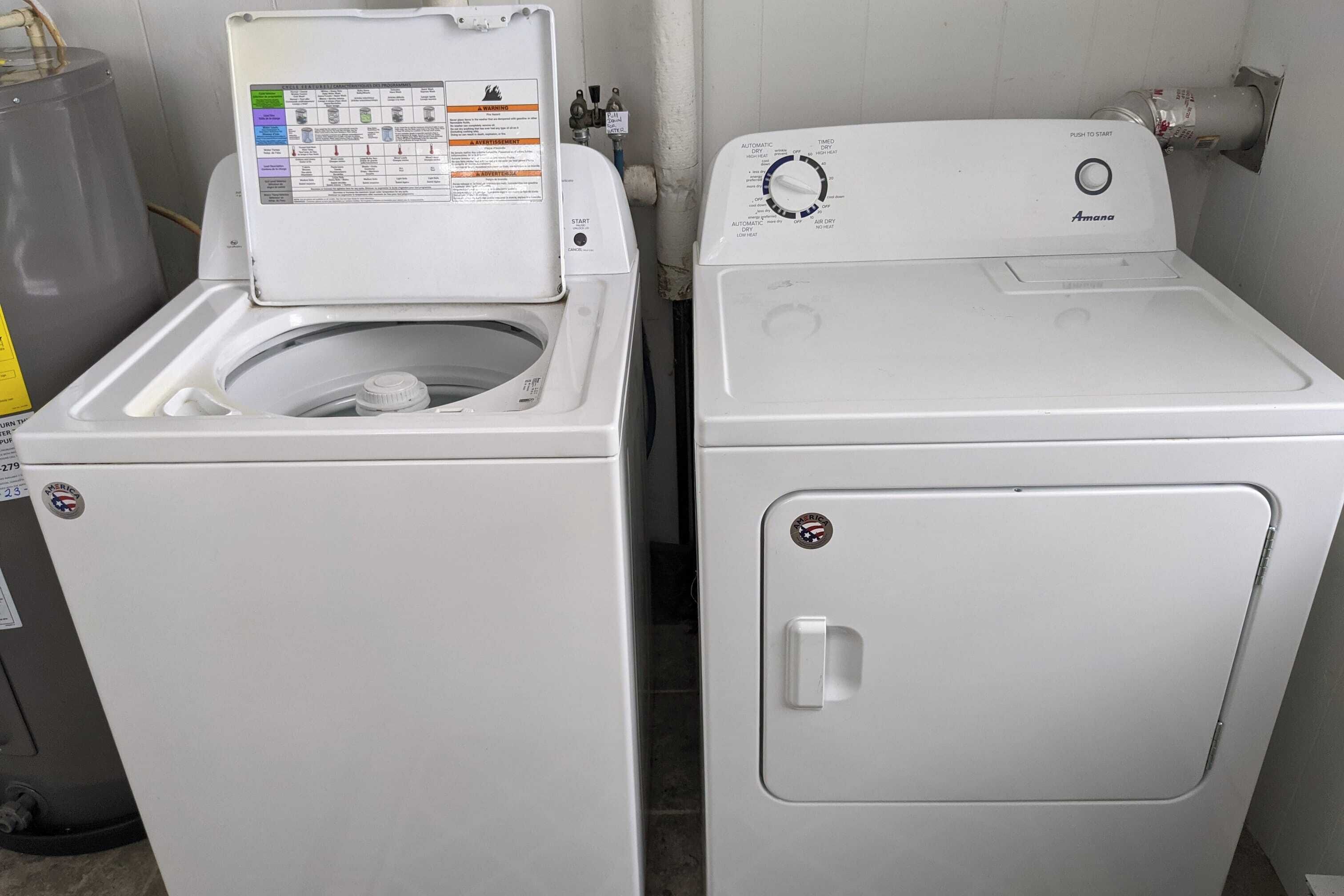 Deux machines à laver blanches, à chargement frontal, sont placées côte à côte dans une buanderie.