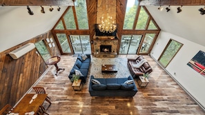 Un loft spacieux doté d’une cheminée, de grandes fenêtres et d’un plancher en bois.