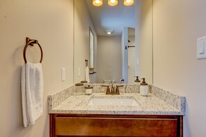 A bathroom with a marble sink, wooden vanity, and a towel rack. - Over the Top Lodge by Avantstay Hot Tub, Shared Pool, Beach/lake Access (Albrightsville)