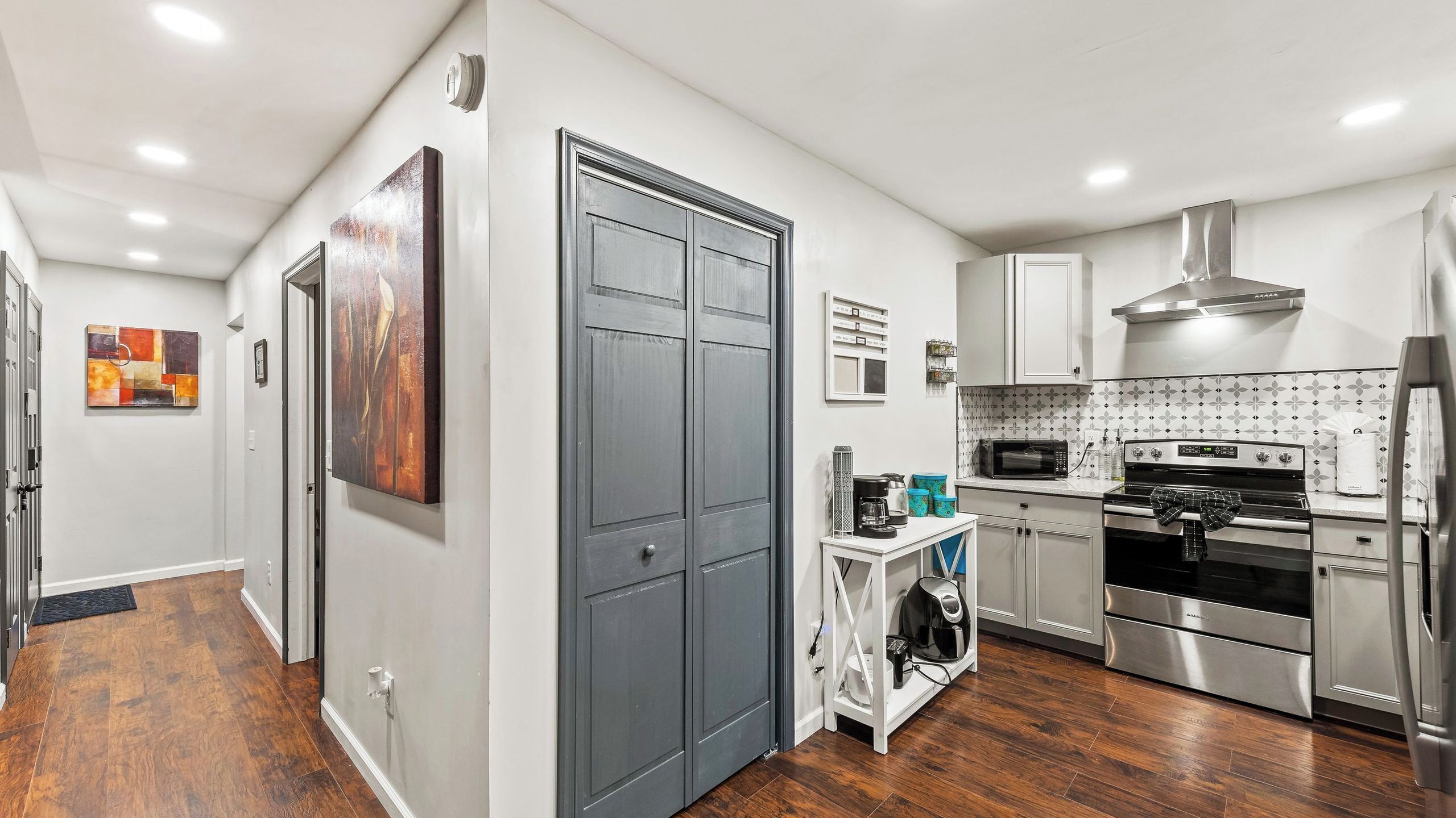 A modern kitchen with a built-in oven, microwave, and stainless steel refrigerator.
