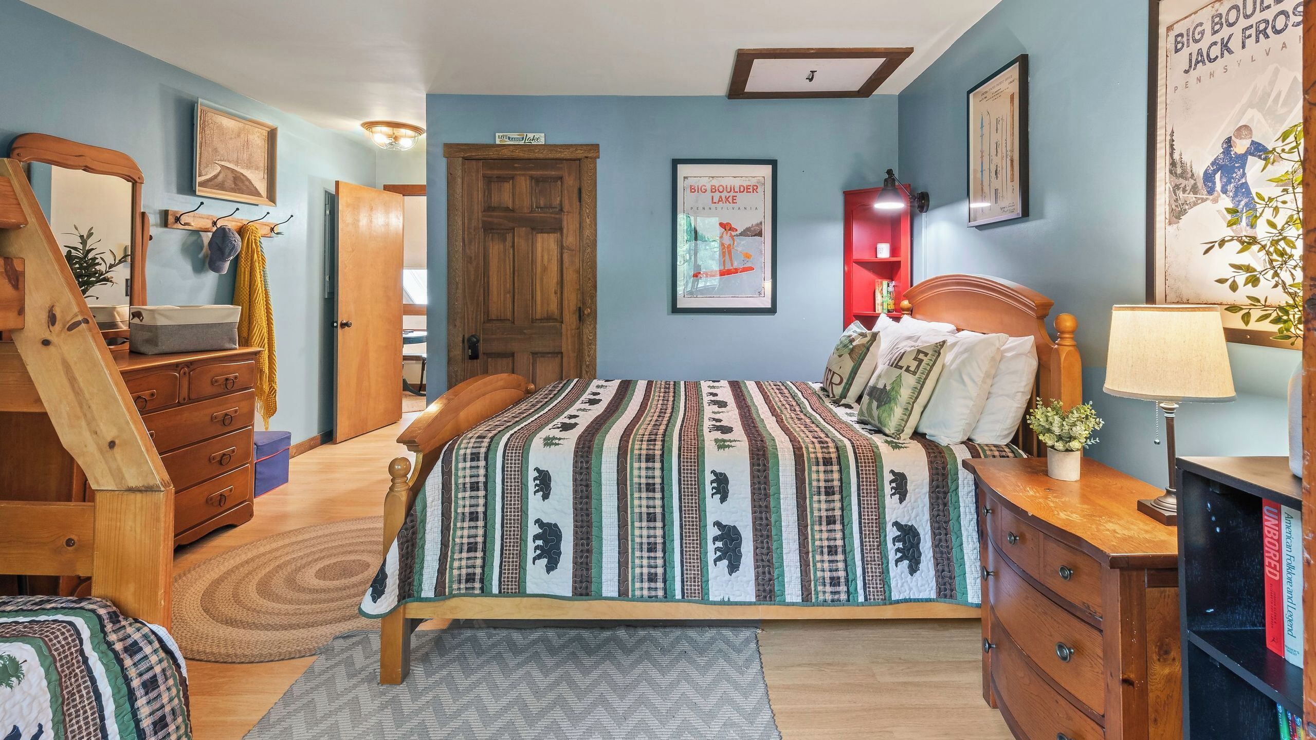 A bedroom with a bed, wooden dresser, and a door.