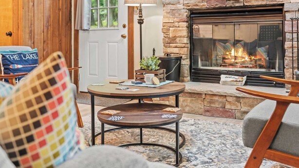 Una sala acogedora con chimenea de piedra, una mesa de centro redonda y asientos cómodos.