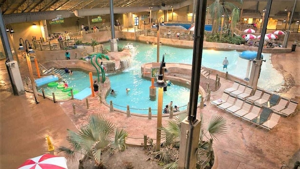 Ein großer Indoor-Wasserpark mit mehreren Pools, Rutschen und Liegebereichen.