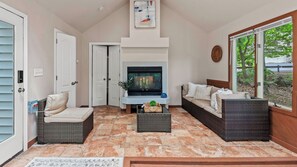 A living room with a TV, two sofas, a coffee table, and a fireplace. - The Boulder Inn by Avantstay Indoor Hot Tub, Game Room, Outdoor Fire Pit (Lake Harmony)