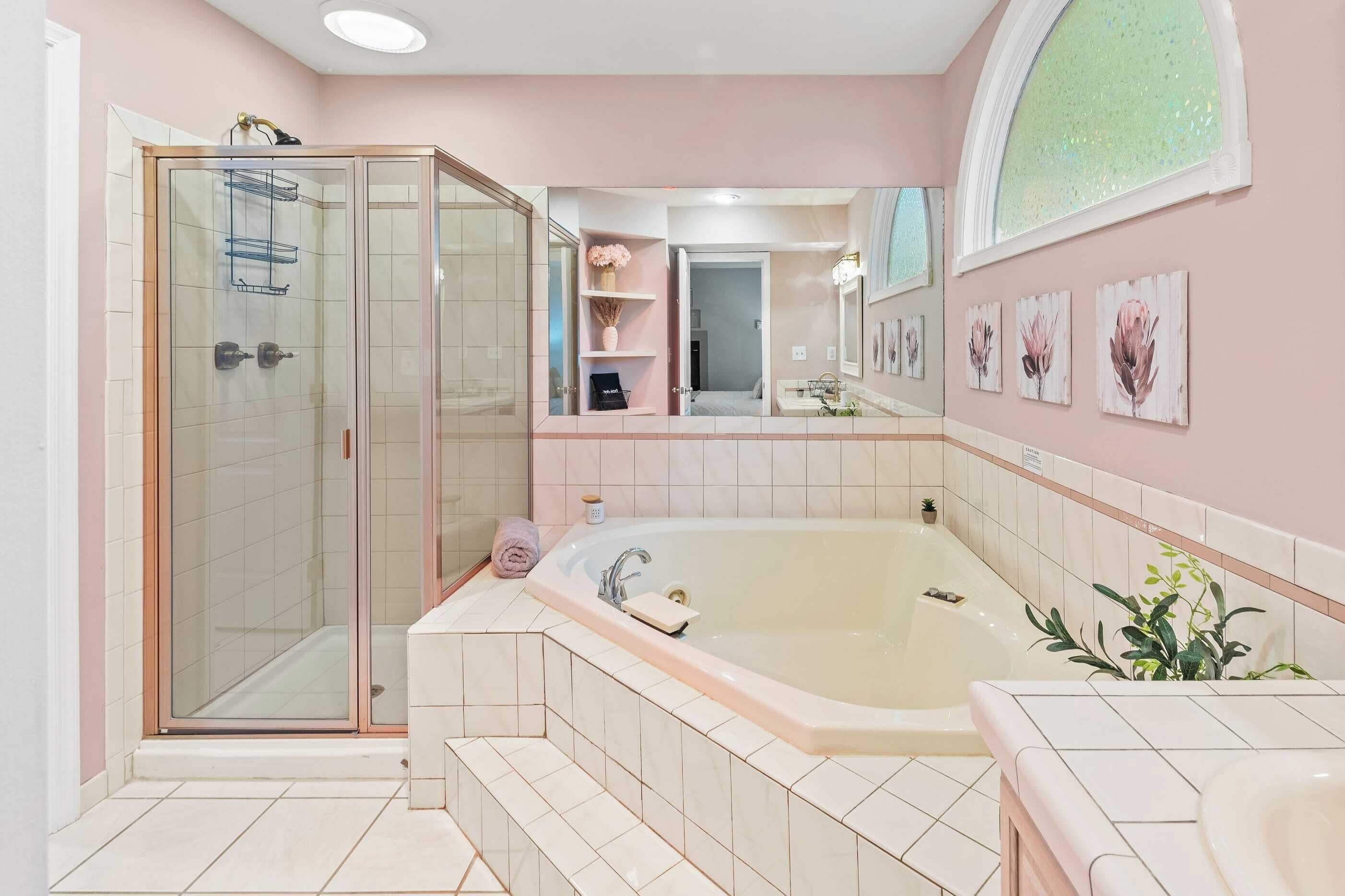 Une salle de bain moderne dotée d’une douche à parois de verre, d’une baignoire sur pieds et d’un meuble-lavabo avec miroir.