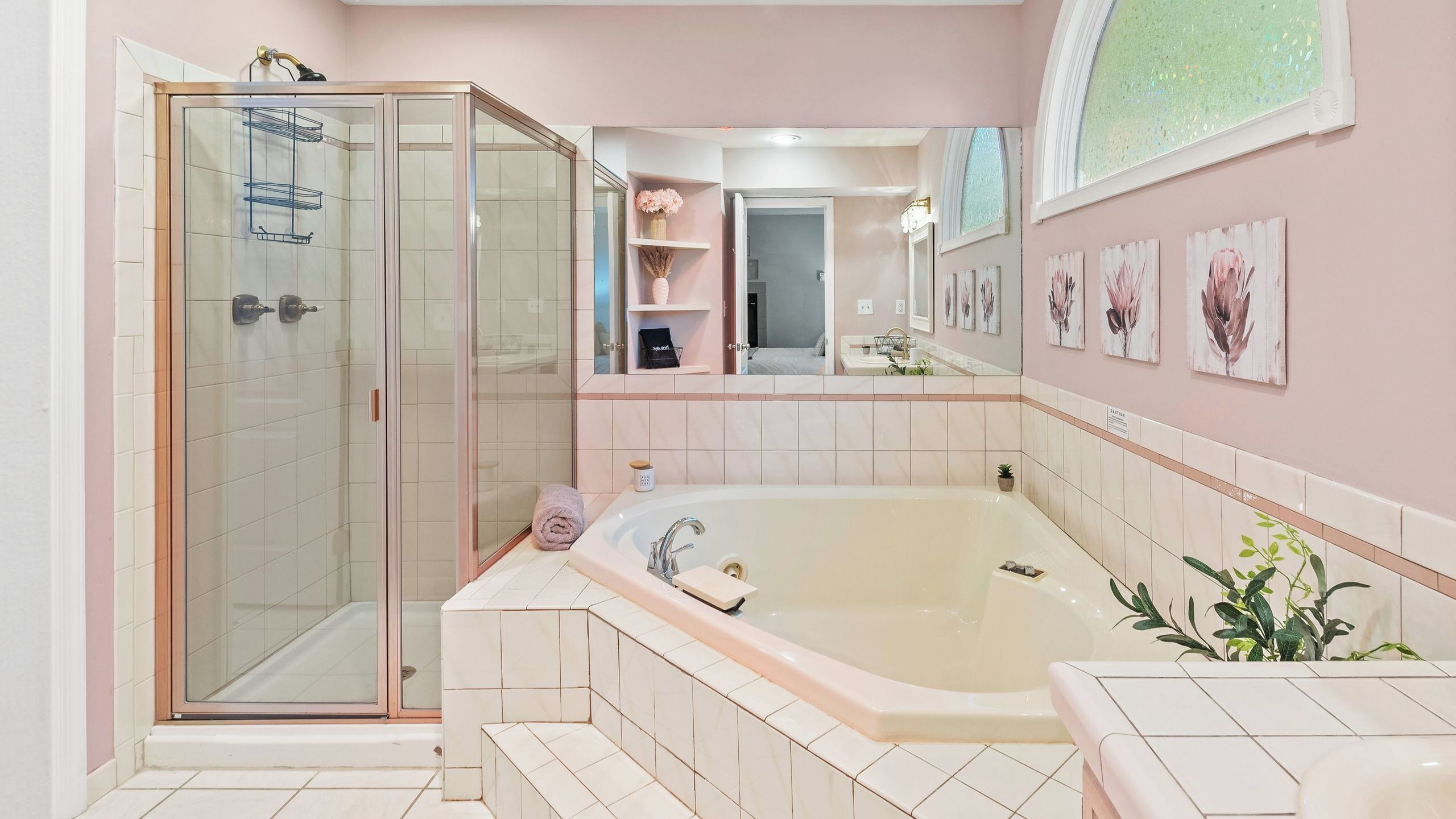 Un baño con ducha envuelta en vidrio, una bañera grande y un tocador con lavabo.