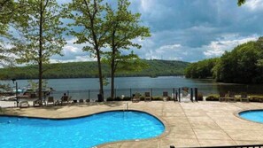 A swimming pool with a view of a lake and trees. - The Boulder Inn by Avantstay Indoor Hot Tub, Game Room, Outdoor Fire Pit (Lake Harmony)